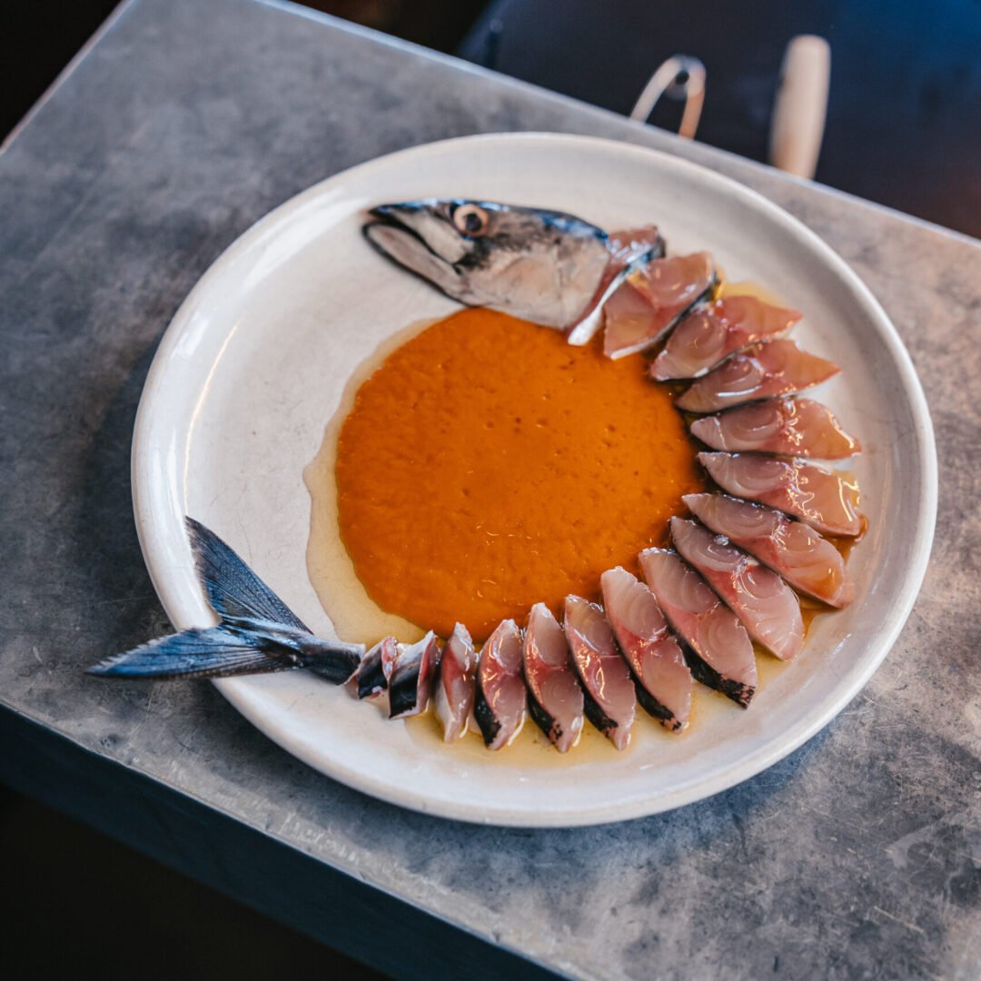 Chef Jamie Lee plating fish at Kødbyens Fiskebaren, Copenhagen